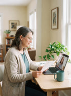 Woman at home on a video call with a clinician, reviewing a printed report.